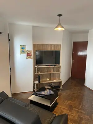 a living room with a couch and a flat screen tv at Pilsen II Guemes in Cordoba