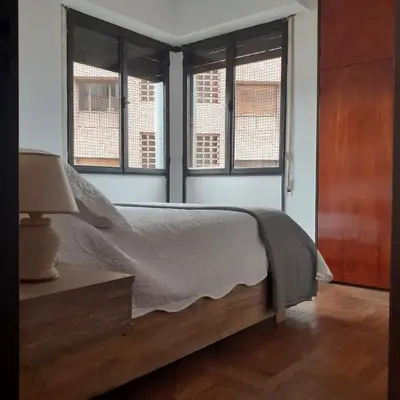a bedroom with a bed and two windows at Pilsen II Guemes in Cordoba