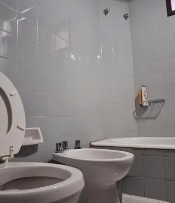 a bathroom with a toilet and a sink and a tub at Pilsen II Guemes in Cordoba