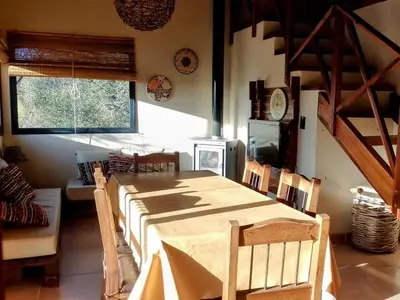 a dining room with a wooden table and chairs at La Serranita in Santa Rosa de Calamuchita