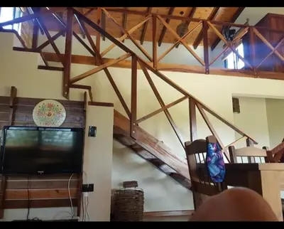 a living room with a tv and a wooden ceiling at La Serranita in Santa Rosa de Calamuchita