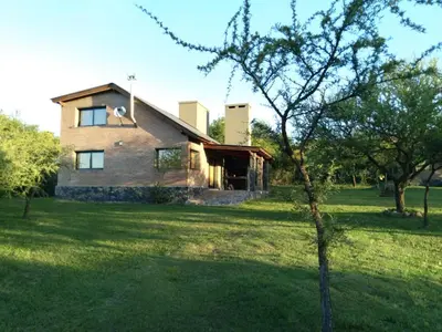 a house in the middle of a green field at La Serranita in Santa Rosa de Calamuchita