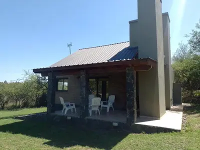 a house with two chairs and a porch at La Serranita in Santa Rosa de Calamuchita