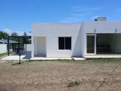 a white house with a white door and windows at Casa Villa Rumipal in Villa Rumipal