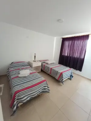 two beds sitting in a room with a window at Casa Villa Rumipal in Villa Rumipal