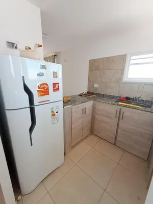 a kitchen with a white refrigerator with a black handle at Casa Villa Rumipal in Villa Rumipal