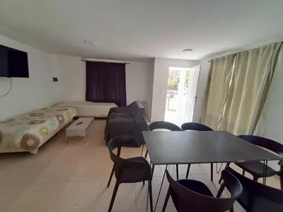 a room with a bed and a table and chairs at Casa Villa Rumipal in Villa Rumipal