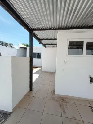 a patio with awning over a white building at Casa Villa Rumipal in Villa Rumipal