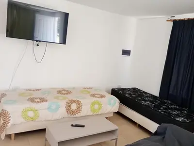 a room with a bed and a flat screen tv at Casa Villa Rumipal in Villa Rumipal