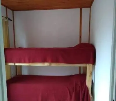 two bunk beds in a room with red sheets at VASOS Y BESOS - Cabaña 1 in Villa Parque Siquiman