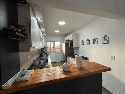 a kitchen with a wooden counter top in a room at Casa Familia Reynoso in Mina Clavero
