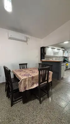 a dining room with a table and chairs and a kitchen at Casa Familia Reynoso in Mina Clavero