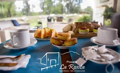 a table with two cups and pastries and bread at Posada La Rosita in Santa Rosa de Calamuchita