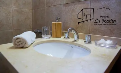 a bathroom sink with a towel and a towel at Posada La Rosita in Santa Rosa de Calamuchita