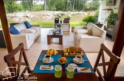 a living room with a table with food on it at Posada La Rosita in Santa Rosa de Calamuchita