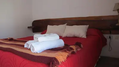 a bed with two towels sitting on top of it at Posada La Rosita in Santa Rosa de Calamuchita