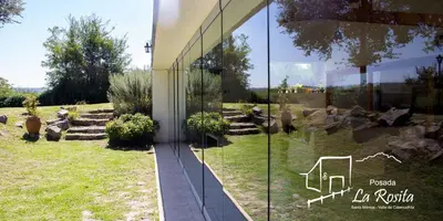 a reflection of a garden in the side of a building at Posada La Rosita in Santa Rosa de Calamuchita