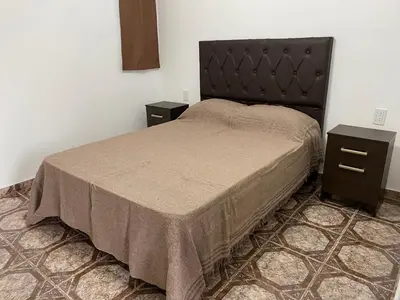 a bedroom with a bed and two night stands at Cabañas Emilia in Mina Clavero