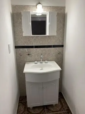 a bathroom with a white sink and a mirror at Cabañas Emilia in Mina Clavero