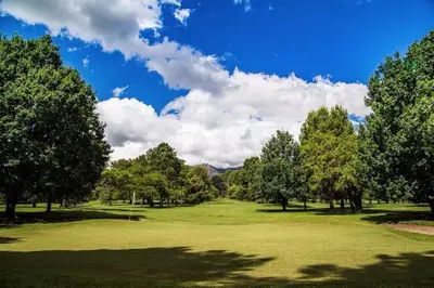 a view of a golf course with trees and a field at Cabaña romántica en la sierra in Yacanto