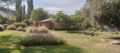 a house in a yard with a garden at Cabaña romántica en la sierra in Yacanto
