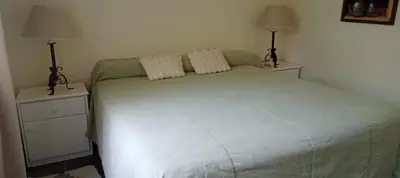 a bedroom with a bed with two night stands and two lamps at Cabaña romántica en la sierra in Yacanto