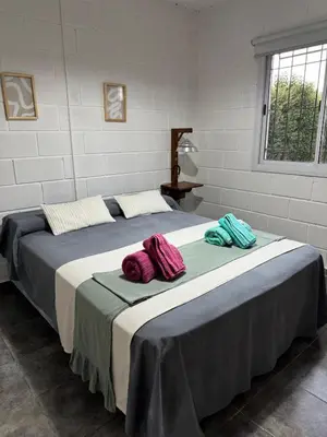 two beds with towels on top of them in a room at La Calandria, Casa de campo in La Estancia