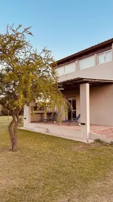 a building with a tree in front of it at La Calandria, Casa de campo in La Estancia
