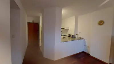 a small white kitchen with a counter and a hallway at Cofico Tradicional in Cordoba