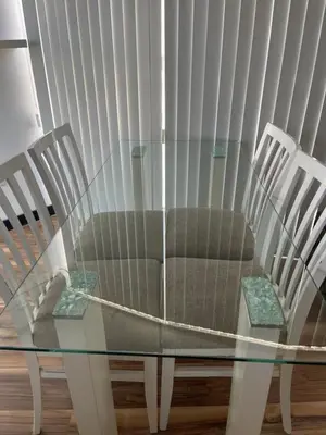 a glass table with a couch and two chairs at Departamento con PILETA y gran balcón terraza con quincho y asador propio in Cordoba