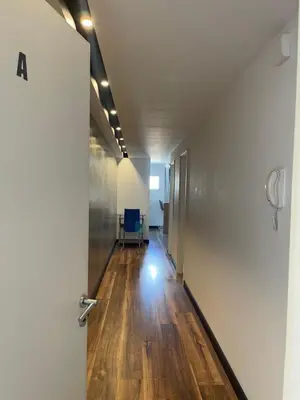 an office hallway with a door and wooden floors at Departamento con PILETA y gran balcón terraza con quincho y asador propio in Cordoba