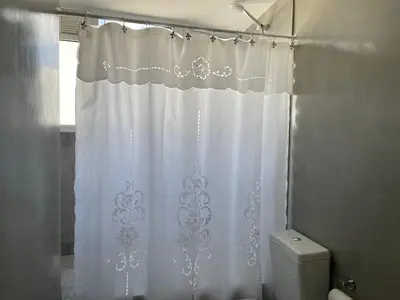 a white shower curtain in a bathroom with a toilet at Departamento con PILETA y gran balcón terraza con quincho y asador propio in Cordoba