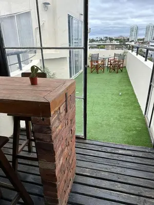a balcony with a table and chairs on a building at Departamento con PILETA y gran balcón terraza con quincho y asador propio in Cordoba