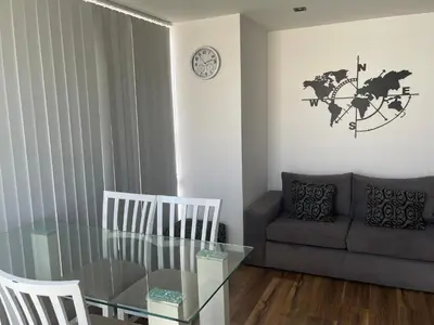 a living room with a glass table and a couch at Departamento con PILETA y gran balcón terraza con quincho y asador propio in Cordoba