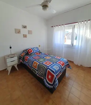 a bedroom with a bed and a table and a window at DEPARTAMENTO RIO TERCERO in Río Tercero