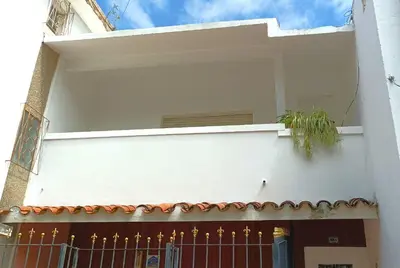 a white building with a fence and a plant on it at DEPARTAMENTO RIO TERCERO in Río Tercero