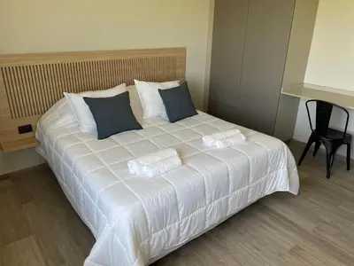 a large white bed with blue pillows in a room at La Morada Almafuerte in Almafuerte