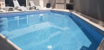 a large blue swimming pool with a bunch of chairs at Duplex Nva Cba, frente al Parque Sarmiento. Excdelentes Amenities in Cordoba