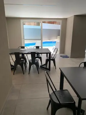 a dining room with tables and chairs and a view of the ocean at Duplex Nva Cba, frente al Parque Sarmiento. Excdelentes Amenities in Cordoba