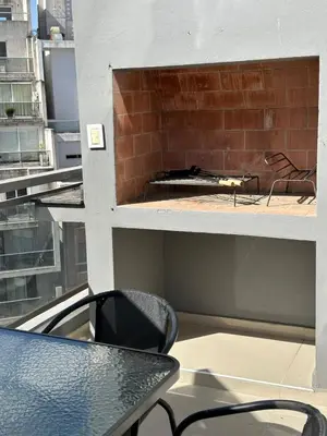 a table and chairs on a balcony with a fireplace at Duplex Nva Cba, frente al Parque Sarmiento. Excdelentes Amenities in Cordoba