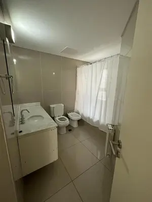 a white bathroom with a toilet and a sink at Duplex Nva Cba, frente al Parque Sarmiento. Excdelentes Amenities in Cordoba