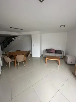 a living room with a table and a couch at Duplex Nva Cba, frente al Parque Sarmiento. Excdelentes Amenities in Cordoba