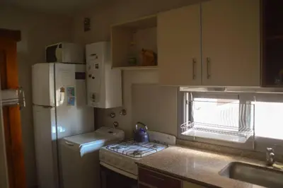 a small kitchen with a refrigerator and a sink at Departamento en Bv. San Juan in Cordoba