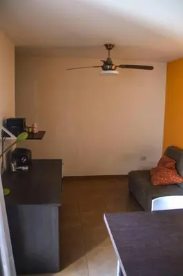 a living room with a ceiling fan and a couch at Departamento en Bv. San Juan in Cordoba