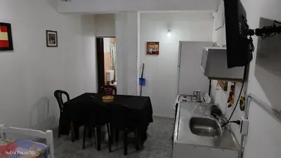 a small room with a table and a kitchen at lo de andres y marina in Arroyo de Los Patos