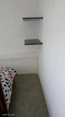 a room with a white wall with a shelf at lo de andres y marina in Arroyo de Los Patos