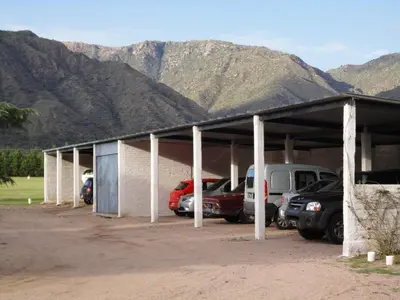 a parking lot with cars parked in front of mountains at Hotel Lujan in Luján