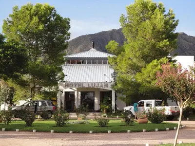 a building with cars parked in front of it at Hotel Lujan in Luján