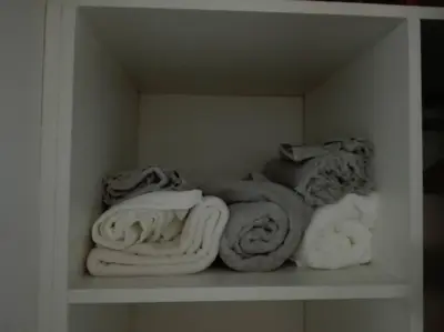 a white shelf filled with towels and blankets at Alto Villasol depto torre bastion in Cordoba