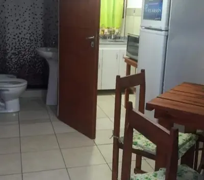 a kitchen with a table and a refrigerator and a table and chair at Cabaña 2 in Cordoba